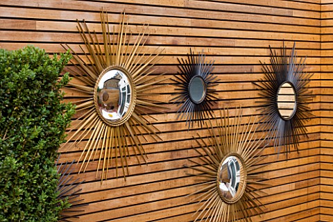 BEN_DE_LISI_HOUSE_AND_GARDEN__LONDON_FRENCH_SIXTIES_SUNBURST_MIRRORS_ON_WALL_IN_THE_GARDEN