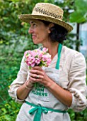 COMMON FARM FLOWERS, SOMERSET, SUMMER: LADY WITH HAT HOLDING BOUQUET OF SWEET PEAS IN THE GARDEN - FLOWER, FLOWERS, POSIE, HANDS