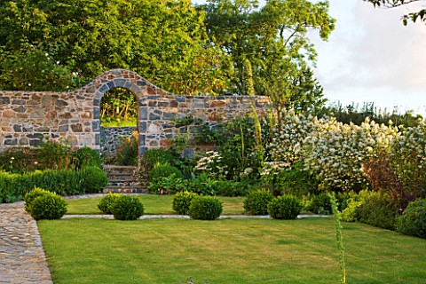 LE_HAUT_GUERNSEY_THE_FRONT_GARDEN_WITH_LAWN_BOX_BALLS_AND_STONE_WALL_WITH_ARCHWAY