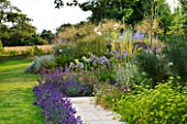 LE HAUT, GUERNSEY: PATH BESIDE LAWN AND HOUSE WITH LAVENDER, AGAPANTHUS AND FENNEL