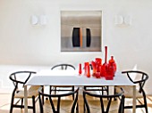BEN DE LISI HOUSE  LONDON: THE WHITE DINING TABLE IN THE KITCHEN WITH RED GLASS AND MURANO PIECES ON THE TABLE
