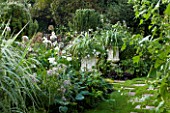 CHENIES MANOR, BUCKINGHAMSHIRE: THE WHITE GARDEN WITH GRASS PATH, HOSTAS, WHITE METAL CONTAINERS WITH ASTELIA AND VERBENA, COUNTRY GARDEN, ROMANTIC, CLASSIC