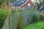 MARCHANTS HARDY PLANTS, EAST SUSSEX: THE HOUSE WITH LAWN AND WAVY CHESTNUT WOODEN FENCE. FENCING, BOUNDARY, BOUNDARIES, COUNTRY, GARDEN, ENGLISH, WOOD