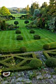 WOOLSTONE MILL HOUSE, OXFORDSHIRE: OVERVIEW FROM FORMAL PARTERRE ACROSS LAWN WITH YEW HEDGES AND BOX FONDANTS. TOPIARY. VIEWS TO COUNTRYSIDE BEYOND. STRUCTURE, SHAPE, FORM, GREEN