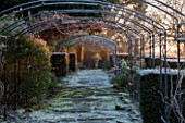 SEDGWICK PARK, WEST SUSSEX. FROSTY SCENE WITH METAL ARCHES IN THE ROSE WALK. WINTER, GARDEN, JANUARY, PATH, VISTA, VIEW, HEDGING.