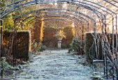 SEDGWICK PARK, WEST SUSSEX. FROSTY SCENE WITH METAL ARCHES IN THE ROSE WALK. WINTER, GARDEN, JANUARY, PATH, VIEW, VISTA, HEDGING