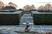 SEDGWICK PARK, WEST SUSSEX. CLIPPED YEW HEDGING IN FORMAL GARDEN WITH BIRDTABLE. FROST, WINTER, JANUARY, PATH, VIEW, VISTA, LANDSCAPE