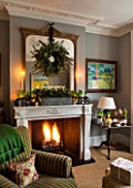 BUTTER WAKEFIELD HOUSE, LONDON. CHRISTMAS: SITTING ROOM WITH FIREPLACE AND WREATH MADE BY BUTTER WAKEFIELD