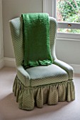 BUTTER WAKEFIELD HOUSE, LONDON. MASTER BEDROOM WITH GREEN OCCASIONAL CHAIR AND THROW