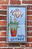 POPS PLANTS AURICULAS, HAMPSHIRE: PORCELAIN AURICULA SIGN BY THE FRONT DOOR OF THE COTTAGE