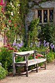 HADDON HALL, DERBYSHIRE: TERRACE BESIDE HALL WITH WOODEN BENCH, ROSES, POPPIES AND IRISES