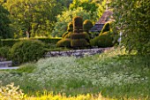HADDON HALL, DERBYSHIRE: WILDFLOWERS AND TOPIARY BESIDE THE RIVER WYE