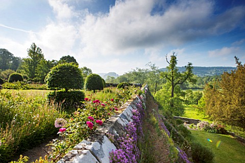 HADDON_HALL_DERBYSHIRE_ROSES_BESIDE_A_WALL_ON_THE_LOWER_GARDEN_WITH_VIEWS_OF_COUNTRYSIDE_BEYOND