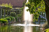 GREAT FOSTERS, SURREY: THE MOAT IN SUMMER WITH FOUNTAIN - WATER, WATER GARDEN, JUNE, FORMAL, POOL, SPOUT, JET, PERGOLA