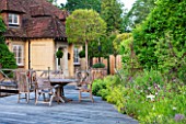 OLD NETLEY MILL, SHERE, SURREY: WOODEN DECKED TERRACE BESIDE THE MILL WITH WOODEN TABLE AND CHAIRS. A PLACE TO SIT, PATIO, SUMMER, JUNE, GARDEN