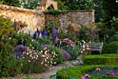 BROUGHTON CASTLE, OXFORDSHIRE: BORDER IN THE WALLED GARDEN WITH ROSES, DELPHINIUMS, ALLIUMS AND OENOTHERA. FLOWERS, SUMMER, JUNE, HERBACEOUS BORDER, GARDEN