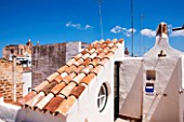 CIUTADELLA MENORCA, SPAIN: EVELYNE MANDEL HOUSE - WHITE PAINTED WALLS - OUTDOOR SHOWER ON ROOF TOP TERRACE WITH VIEWS OF ROOF TOPS OF CIUTADELLA