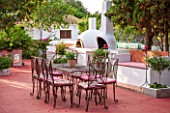 JONATHAN BAILLIE GARDEN, ALAIOR, MENORCA: PATIO WITH RED FLOOR, METAL TABLE AND CHAIRS, BARBEQUE AND PIZZA OVEN. A PLACE TO SIT, DINING AREA, MEDITERRANEAN, RELAX, RELAXING
