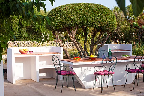 JONATHAN_BAILLIE_GARDEN_ALAIOR_MENORCA_BUILT_IN_BARBEQUE_AND_TABLE_WITH_METAL_CHAIRS_SURROUNDED_BY_C