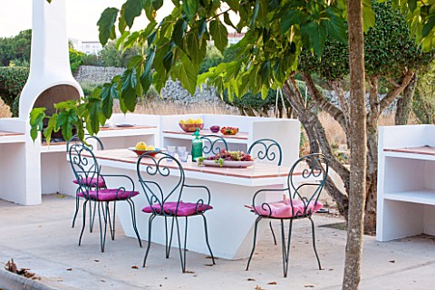 JONATHAN_BAILLIE_GARDEN_ALAIOR_MENORCA_BUILT_IN_BARBEQUE_AND_TABLE_WITH_METAL_CHAIRS_SURROUNDED_BY_C