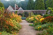 WEST DEAN GARDENS, WEST SUSSEX: LATE SUMMER BORDERS IN THE WALLED VEGETABLE GARDEN - PATH TO SEAT / BENCH - ORANGE THEMED BORDER - HOT, WARM, FLOWER, FLOWER BEDS