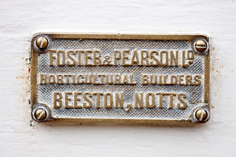 WEST_DEAN_GARDENS_WEST_SUSSEX_DETAIL_OF_MAKERS_NAME_PLATE_ON_THE_DOOR_OF_A_GLASSHOUSE__GREENHOUSE_RO