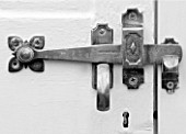 WEST DEAN GARDENS, WEST SUSSEX: BLACK AND WHITE IMAGE OF BRASS DOOR HANDLE ON THE DOOR OF A GLASSHOUSE / GREENHOUSE ROOF IN THE WALLED KITCHEN GARDEN. AUGUST