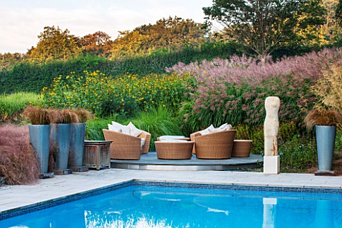 SURREY_GARDEN_DESIGNED_BY_ANTHONY_PAUL_SWIMMING_POOL_WITH_TERRACE__RATTEN_FURNITURE_CUSHIONS_CAREX_F