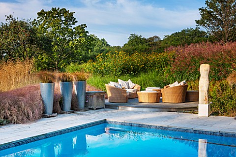 SURREY_GARDEN_DESIGNED_BY_ANTHONY_PAUL_SWIMMING_POOL_WITH_TERRACE__RATTEN_FURNITURE_CUSHIONS_CAREX_F