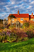 RYE HALL FARM, YORKSHIRE - DESIGNER SARAH MURCH - COUNTRY GARDEN WITH LATE SUMMER / AUTUMN GRASSES AND PERENNIALS. LAWN, ORNATE METAL GAZEBO, GARDEN ORNAMENT, HOUSE, OCTOBER