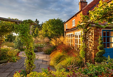 RYE_HALL_FARM_YORKSHIRE__DESIGNER_SARAH_MURCH__COUNTRY_GARDEN_WITH_GRASSES_IN_OCTOBER_HOUSE_WITH_PAT