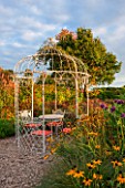 RYE HALL FARM, YORKSHIRE - DESIGNER SARAH MURCH - COUNTRY GARDEN WITH RUSTIC WHITE PAINTED METAL GAZEBO AND TABLE AND CHAIRS, RUDBECKIA - A PLACE TO SIT, AUTUMN, OCTOBER