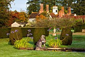 HOLE PARK, KENT: FORMAL ITALIAN POOL / POND GARDEN IN FRONT OF THE HOUSE WITH FOUNTAINS, AGAPANTHUS HOLE PARK BLUE AND CLIPPED TOPIARY SHAPES - EARLY MORNING, DAWN, AUTUMN, OCTOBER