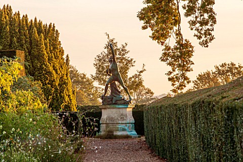 HOLE_PARK_KENT_VIEW_ALONG_GRAVEL_PATH_TO_STATUE_OF_EAGLE_SLAYER__DAWN_WALLED_GARDEN_COUNTRY_GARDEN_C