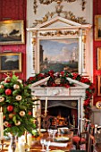 CASTLE HOWARD, YORKSHIRE: CHRISTMAS - THE CRIMSON DINING ROOM DECORATED FOR CHRISTMAS WITH CANDLES AND CHRISTMAS DECORATIONS - DECORATIVE, ORNAMENT, WINTER, NOVEMBER, FIREPLACE
