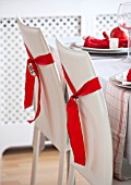SALTWATER, NORFOLK : DESIGNER KAREN MOORE - CHRISTMAS, DECEMBER, WINTER - THE DINING ROOM IN RED AND WHITE - TABLE, CHAIRS, RIBBONS, DECORATION
