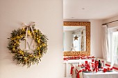 SALTWATER, NORFOLK : DESIGNER KAREN MOORE - CHRISTMAS, DECEMBER, WINTER - THE DINING ROOM IN RED AND WHITE - TABLE, CHAIRS, RIBBONS, DECORATION, LIGHTS, CANDLES, DINNER, WREATH