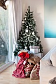 SALTWATER, NORFOLK : DESIGNER KAREN MOORE - CHRISTMAS, DECEMBER, WINTER - WHITE LIVING ROOM WITH ALUMINIUM PHOTOGRAPH BY HARRY CORY WRIGHT, CHRISTMAS PRESENTS AND CHRISTMAS TREE
