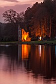 PAINSHILL PARK, SURREY: THE RUINED ABBEY SEEN ACROSS THE LAKE, LIT UP AT NIGHT - LIGHTING, HISTORIC, LAKE, WATER, LANDSCAPE, WINTER, DECEMBER, CHRISTMAS, REFLECTION, REFLECTIONS