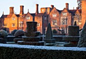 GREAT FOSTERS. SURREY: THE HOTEL AND FORMAL TOPIARY GARDEN IN WINTER - CLIPPED, SHAPED, EVERGREEN, SHRUBS, HEDGES, HEDGING, CLASSIC COUNTRY GARDEN, JANUARY, FROST, FROSTY, FROSTED