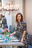 SALLY STOREY HOUSE, LONDON: SALLY STOREY IN DINING AREA - WOODEN TABLE, DINING CHAIRS, CHANDELIER AND BANQUETTE SEATING, MIRROR, TULIPS. ENTERTAINING, SEAT, SEATS, LIGHTING, LIGHTS