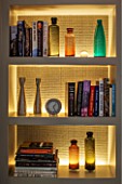 SALLY STOREY HOUSE, LONDON: BOOKS AND GLASS JARS IN SHELF UNIT IN MASTER BEDROOM - LIGHT, LIGHTS, LIGHTING