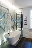 SALLY STOREY HOUSE, LONDON: WHITE AND GREY BATHROOM WITH BOOKMATCHED MARBLE WALL, BATH AND TOWEL RAIL - LIT, LIGHT, LIGHTING, LIGHTS