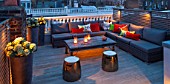 SALLY STOREY HOUSE, LONDON: ROOF TERRACE / GARDEN - WOODEN TABLE, CANDLES, SEATING WITH CUSHIONS - LIT UP AT NIGHT, LIGHTS, LIGHTING, CONTAINERS WITH HYDRANGEAS