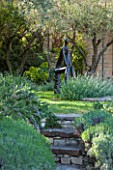 LA JEG, PROVENCE, FRANCE: DESIGNER ANTHONY PAUL - STONE STEPS PAST ROSEMARY TO SCULPTURE BY HELEN SINCLAIR. FRANCE, ORNAMENT, MEDITERRANEAN, FORMAL, GARDEN