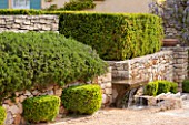 LA JEG, PROVENCE, FRANCE: DESIGNER ANTHONY PAUL - STONE WALL, FOUNTAIN, CLIPPED TOPIARY. MEDITERRANEAN, GARDEN, PROVENCE, MAY, PRUNED, HEDGING, HEDGE