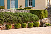 LA JEG, PROVENCE, FRANCE: DESIGNER ANTHONY PAUL - STONE WALL, FOUNTAIN, CLIPPED TOPIARY. MEDITERRANEAN, GARDEN, PROVENCE, MAY, PRUNED, HEDGING, HEDGE, DRIVE, HOUSE, SHUTTERS