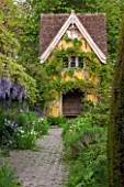 BRYANS GROUND, HEREFORDSHIRE: THE TERRACE BEHIND THE HOUSE WITH WISTERIA AND VIEW TO DOVECOTE DESIGNED BY SIMON DORRELL - COUNTRY GARDEN, BUILDING, MAY, SPRING