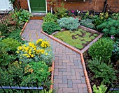 DOGLEG PATH OF BRICK AND TERRACOTTA ROPE-TWIST EDGING AND LAWN OF CORSICAN MINT. DESIGNER: JEAN BISHOP