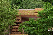 PRIVATE GARDEN LONDON DESIGNED BY LUCY WILLCOX AND ANA SANCHEZ MARTIN: CORTEN STEEL LOG STORE AND LIVING ROOF ON COVERED SEATING AREA.. LOGS, FIRE PIT, BUG HOTEL, WILDLIFE FRIENDLY